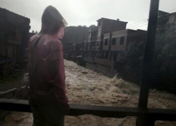 Seorang lelaki menyaksikan 
banjir ketika hujan lebat yang melanda Ningde,  China , 9 Ogos 2015. REUTERS/Stringer