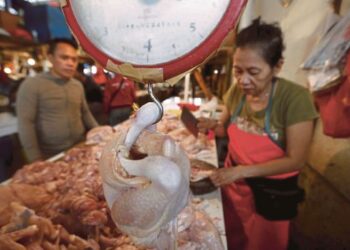 SEORANG peniaga memotong ayam untuk seorang pelanggan di Pasar Senen, Jakarta, semalam. Foto oleh Reuters