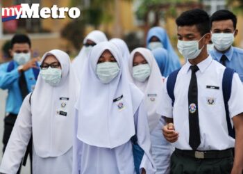 Pelajar diarah memakai topeng ketika keluar selepas tamat sesi sekolah Sekolah Menengah Kebangsaan Seri Ampang, Kuala Kedah, hari ini. - Foto oleh BERNAMA