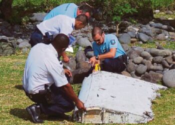 Gambar fail menunjukkan pegawai Perancis memeriksa kepingan sisa pesawat yang ditemui di pantai Saint Andre, Pulau Reunion Perancis di Lautan Hindi pada 29 Julai lalu. Foto dari Harian Metro