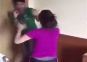 Paparan skrin video wanita (baju ungu) yang memukul lelaki dan pasangannya dalam keadaan bogel di hotel di Golok, Thailand.
