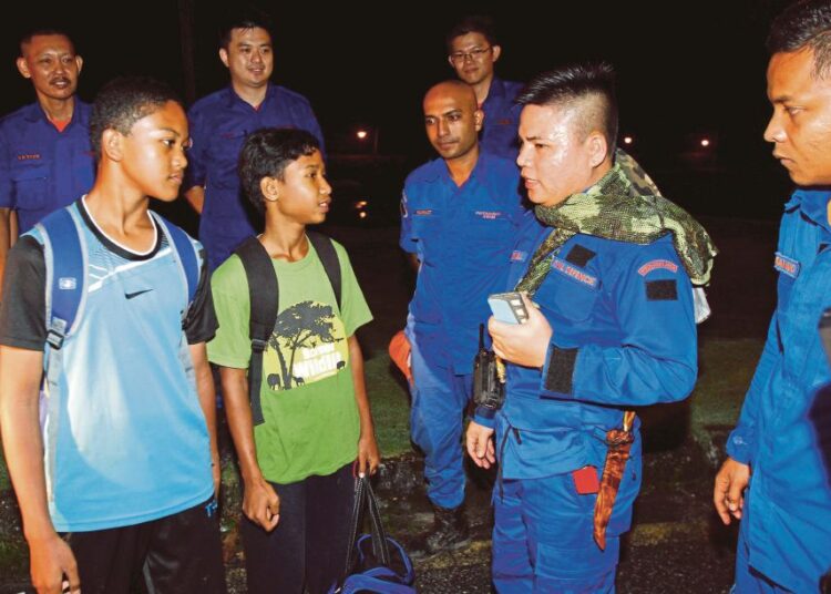 Shahrul ((kiri) dan Mohd Aiman (dua dari kiri) mengucapkan terima kasih kepada anggota penyelamat. Foto - Harian Metro