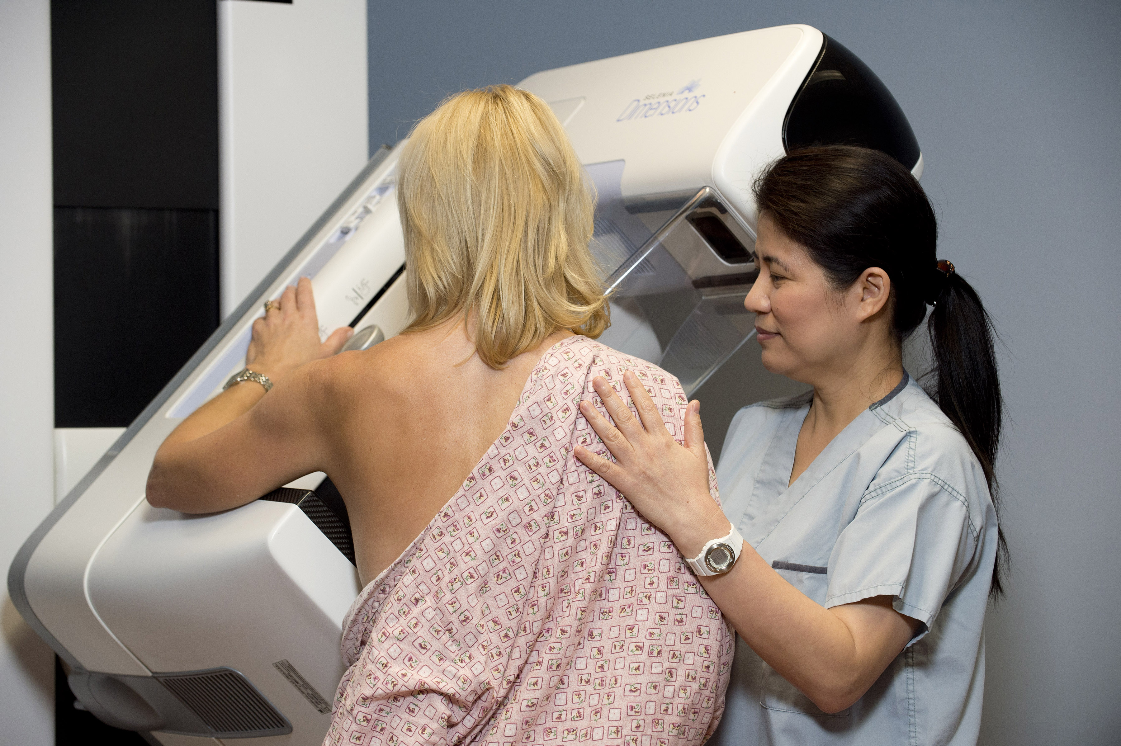 Technologist helping woman with a mammogram